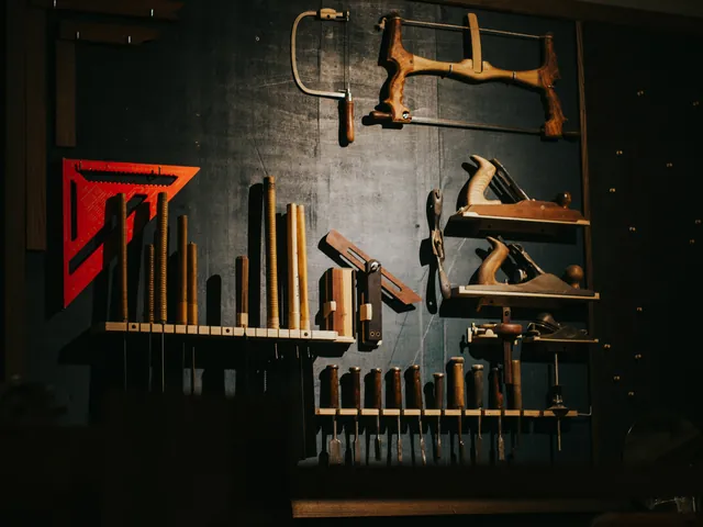 Handwerkzeug hängt an einer dunklen Werkstattwand