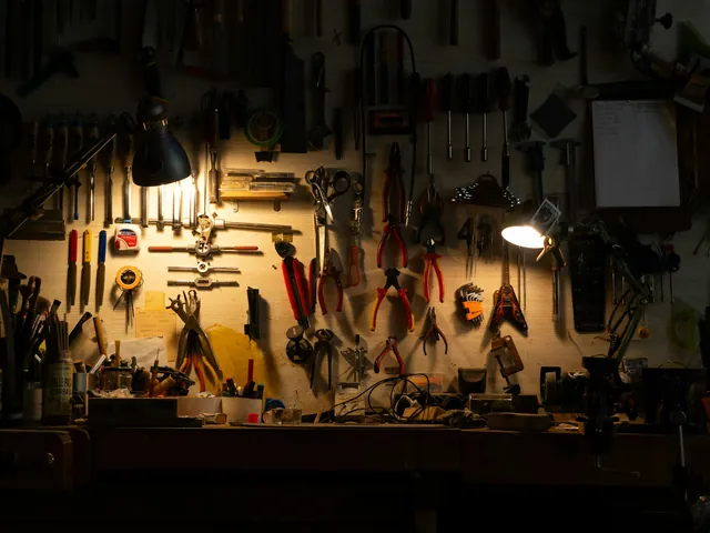 Werkbank mit Zangen und Werkzeug an der Wand im Licht zweier Lampen