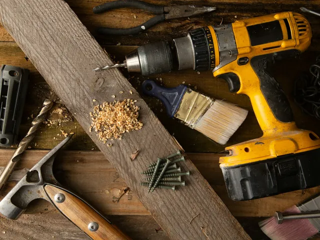 Werkzeuge, Holz und Bohrmaschine auf einer Werkbank