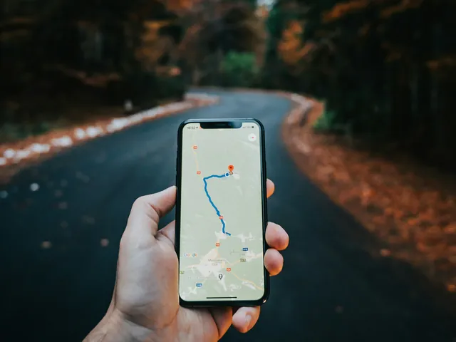 Hand hält ein Smartphone mit geöffneter Kartenansicht